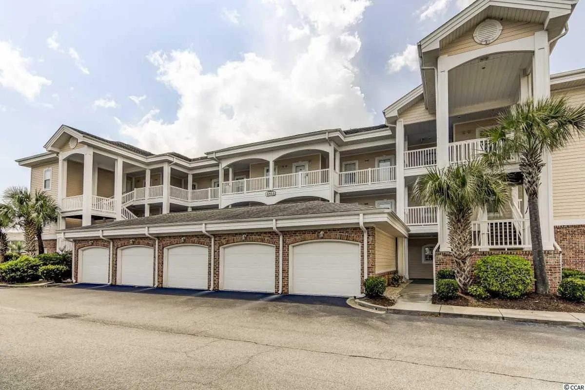 This exterior image features the building's balconies overlooking palm trees and the charming architecture of the Magnolia Pointe community. The view hints at elevated perspectives, perfect for catching glimpses of the golf course action below or relaxing after a game. The visible balconies reinforce the top-floor vantage point and the connection between the interior retreat and the surrounding environment.