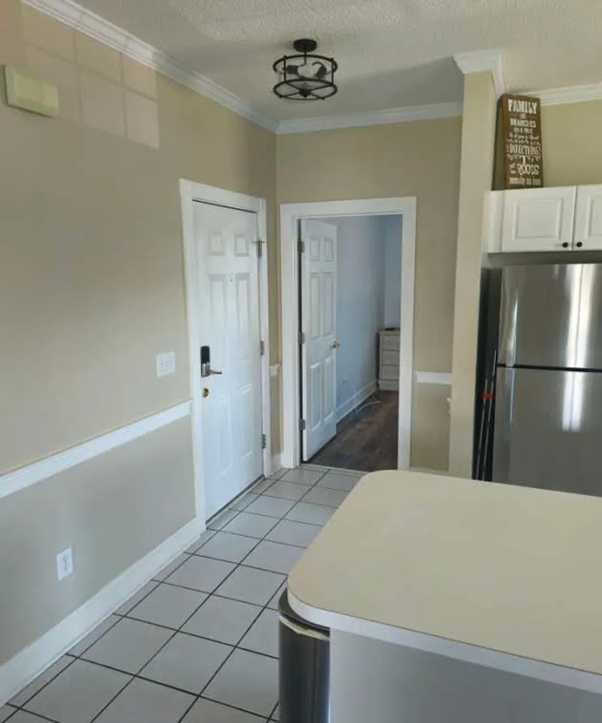 This inviting kitchen scene showcases a large kitchen island, a refrigerator, and multiple doorways leading to adjacent social spaces. The layout is open and conducive to both meal preparation and entertaining guests, capturing the communal spirit described in the section.